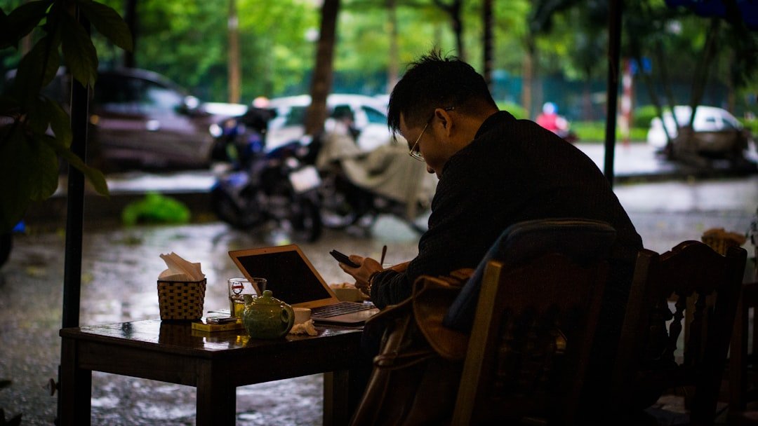Solo traveler reviewing budget spreadsheet on phone at outdoor cafe table